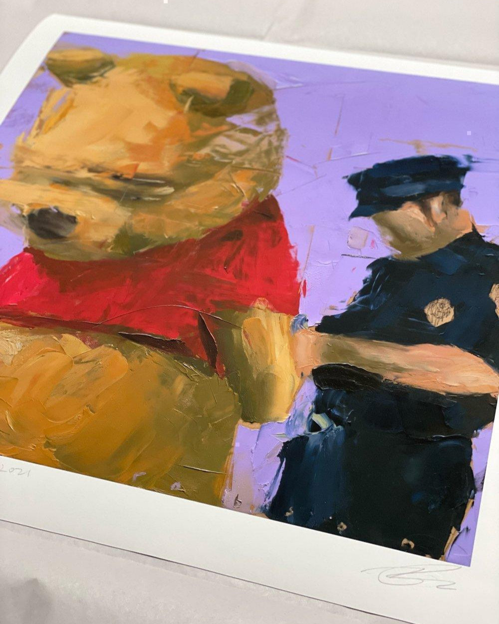 Pooh Under Arrest’ limited edition art print by Brad Robson, physical print displayed on table